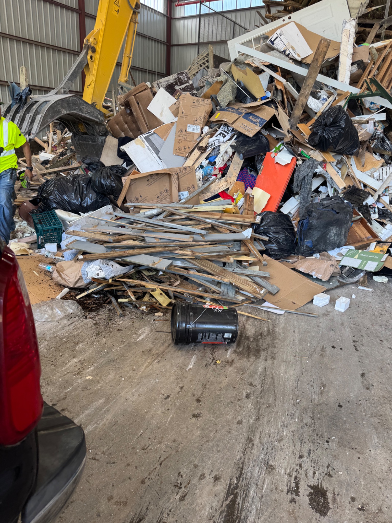 Mixed wood, cardboard, bags, and household debris prepared for removal